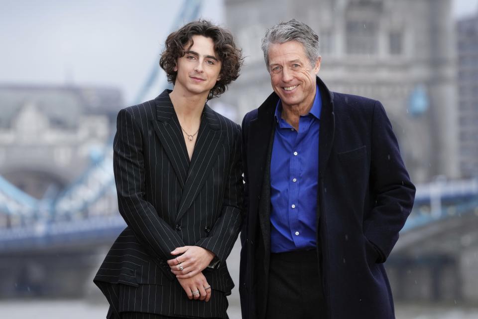 Timothee Chalamet, izquierda, y Hugh Grant posan a su llegada a una sesión fotográfica de la película "Wonka" en Londres, el lunes 27 de noviembre de 2023. (Foto Scott Garfitt/Invision/AP)