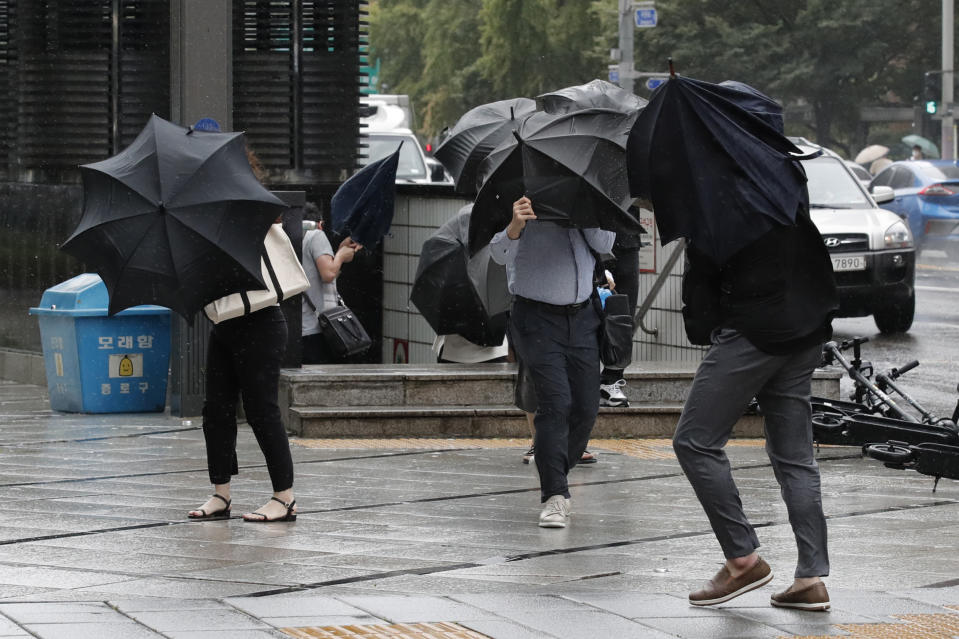 People struggle with their umbrellas against strong wind and rain in downtown Seoul, South Korea, Thursday, Sept. 3, 2020. A powerful typhoon ripped through South Korea’s southern and eastern coasts with tree-snapping winds and flooding rains Thursday, knocking out power to thousands of homes. (AP Photo/Lee Jin-man)