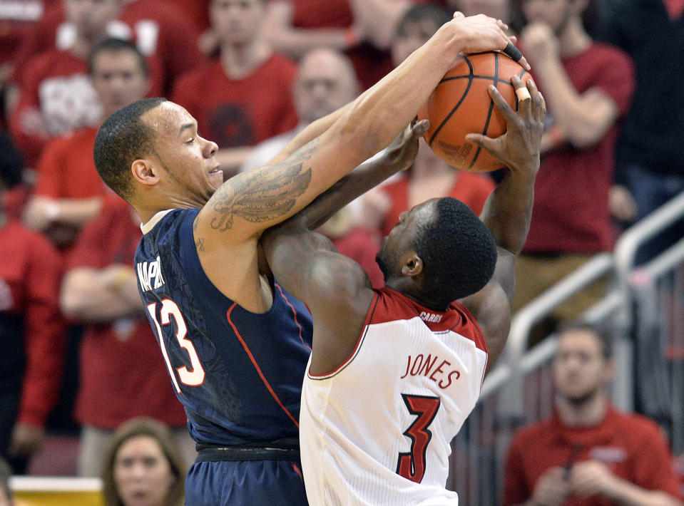 FILE - In this March 8, 2014 file photo, Connecticut's Shabazz Napier, left, blocks the shot of Louisville's Chris Jones during the first half of an NCAA college basketball game in Louisville, Ky. Napier was selected to The Associated Press All-America team, released Monday, March 31, 2014. (AP Photo/Timothy D. Easley, File)