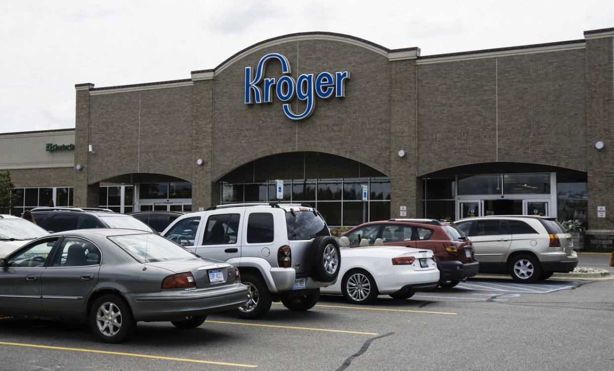 An outside view of Kroger with customers parked cars.