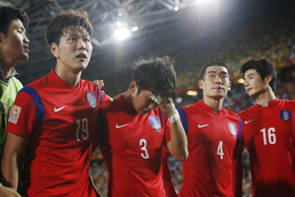 South Korea's Kim Jin-su is consoled by team mate Kim Young-gwon after losing their Asian Cup final soccer match to Australia at the Stadium Australia in Sydney