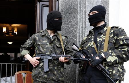 Pro-Russian armed men stand at the entrance to the regional government headquarters in Luhansk, eastern Ukraine, April 30, 2014. REUTERS/Vasily Fedosenko