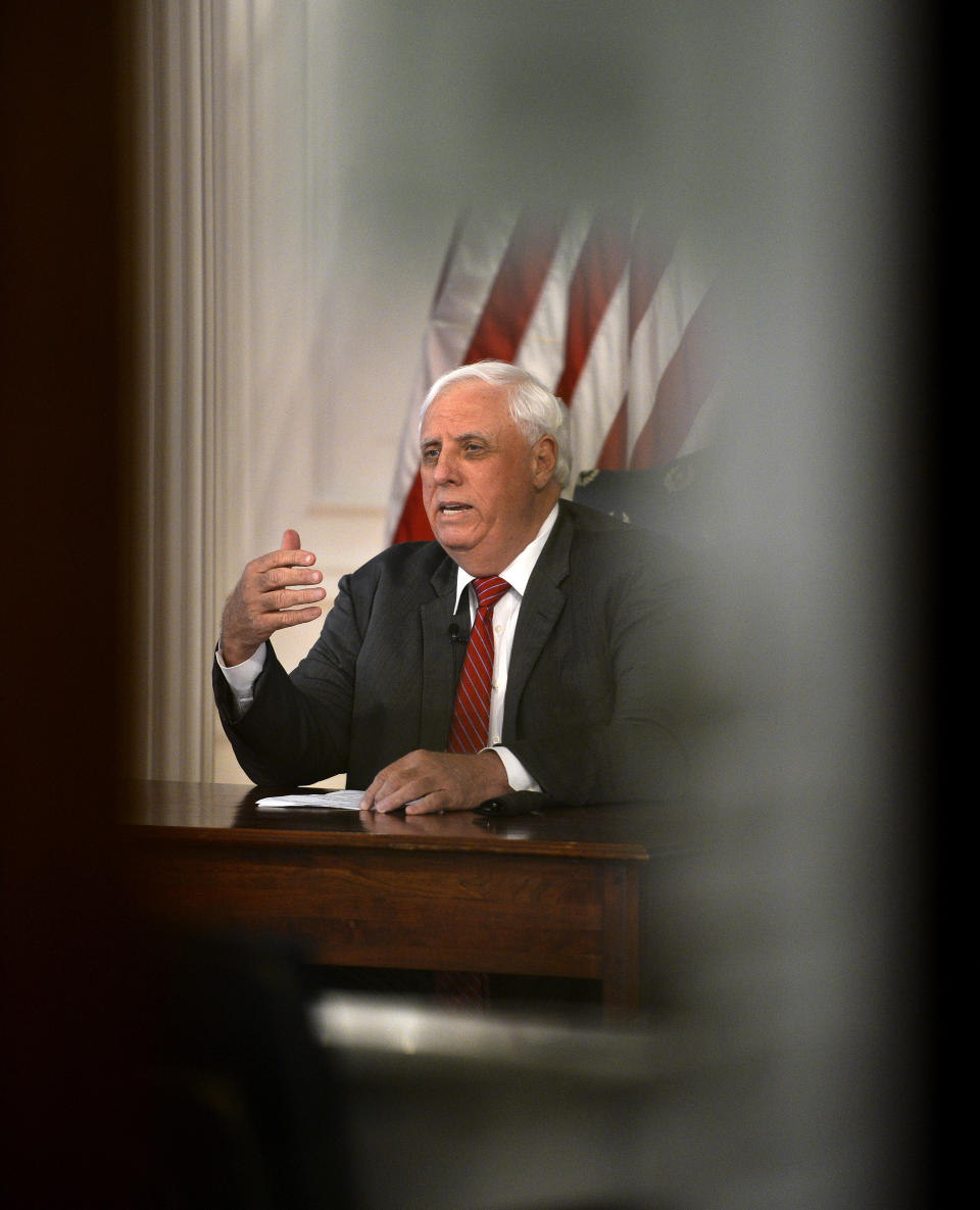 West Virginia governor Jim Justice Monday, March, 23, 2020, issued a stay at home order, effective 8 p.m. Tuesday from his office in the WV State Capitol in Charleston, W. Va. Orders all non-essential businesses closed. (Kenny Kemp/Charleston Gazette-Mail via AP)