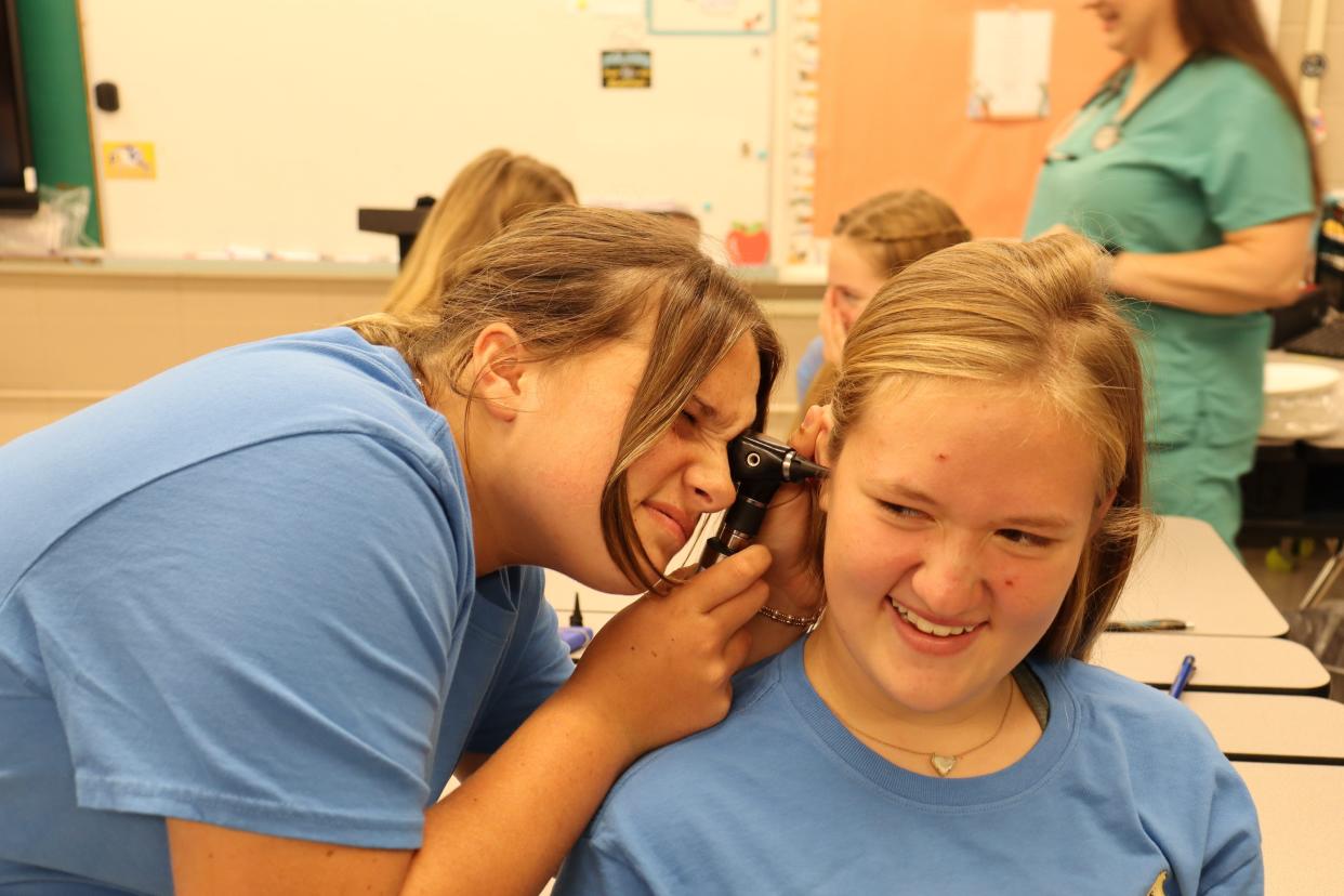 Aubrey Hebert looks into the ear of Malia Perkins using an otoscope. The 13-year-old girls were participating in a MedStart class on Oct. 11 at Poland Junior High School.