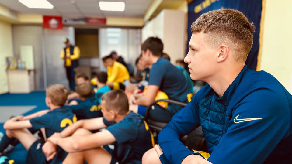 Matviy Kolotay, an academy player at FC Metalist Kharkiv, watches the first team play a match after Saturday training. - Daria Tarasova-Markina/CNN 