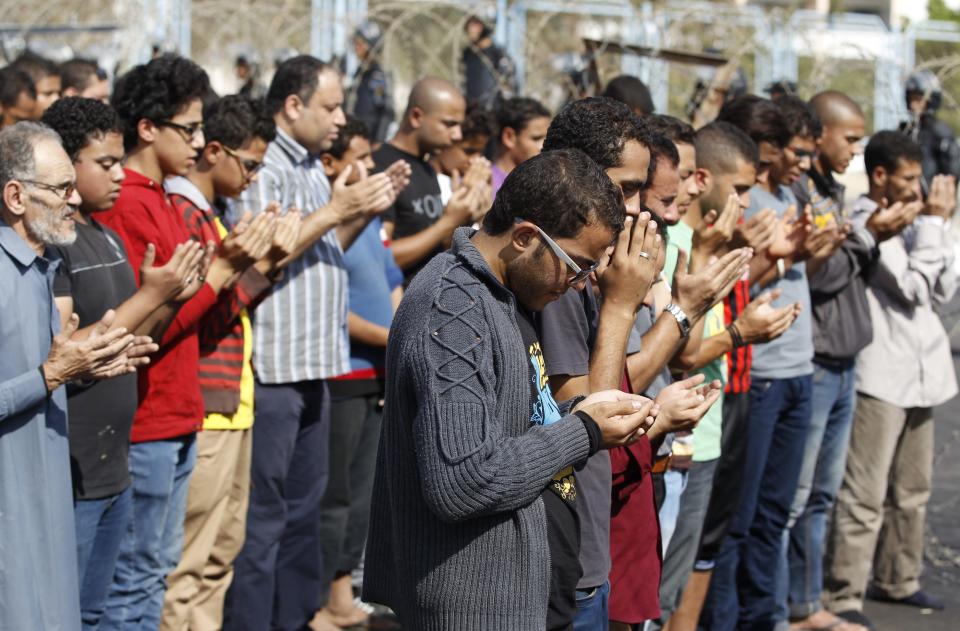 Supporters of the Muslim Brotherhood and ousted Egyptian President Mohamed Mursi pray outside the police academy, where Mursi's trial took place, on the outskirts of Cairo, November 4, 2013. Mursi struck a defiant tone on the first day of his trial on Monday, chanting 'Down with military rule', and calling himself the country's only 'legitimate' president. Mursi, an Islamist who was toppled by the army in July after mass protests against him, appeared angry and interrupted the session repeatedly, prompting a judge to adjourn the case. REUTERS/Amr Abdallah Dalsh (EGYPT - Tags: POLITICS CIVIL UNREST)