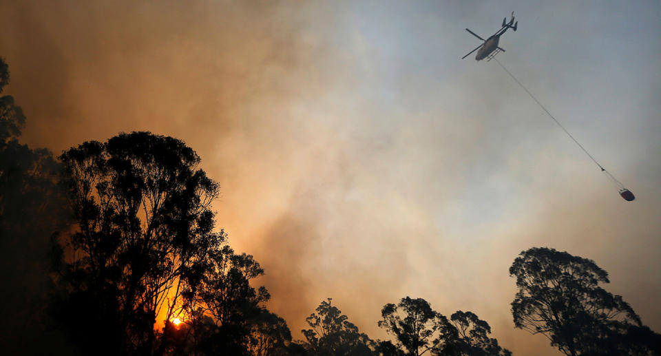 Photo shows water about to be dropped on fire in NSW by helicopter.