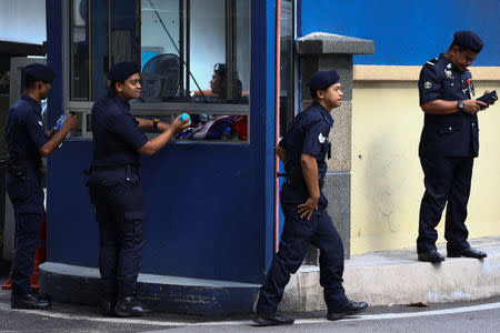 Malaysian police officers gather in front of the gate of the morgue at Kuala Lumpur General Hospital where Kim Jong Nam's body is held for autopsy in Malaysia February 21, 2017. REUTERS/Athit Perawongmetha