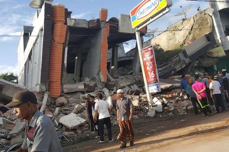 People survey the damage after dozens of buildings collapsed following a 6.4 magnitude earthquake in Ule Glee, Pidie Jaya in the northern province of Aceh, Indonesia December 7, 2016. REUTERS/Nunu Husien