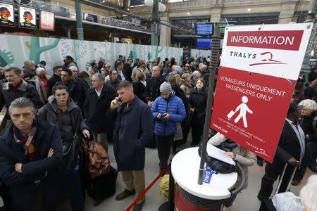 Travellers gather near a Thalys information sign at the Gare du Nord train station after a power outage that has suspended main line services, including the Eurostar, RER commuter trains and suburban train services at the station in Paris, France, December 7, 2016. REUTERS/Yves Herman