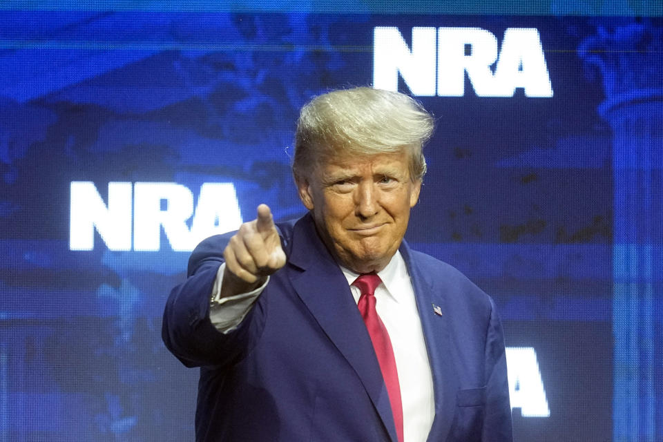 El expresidente Donald J. Trump señala con el dedo durante la convención de la Asociación Nacional del Rifle, el viernes 14 de abril de 2023, en Indianápolis. (AP Foto/Darron Cummings)