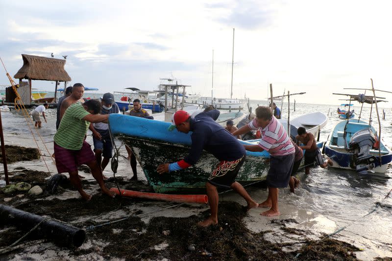 FILE PHOTO: Fishermen take a boat off the water as Hurricane Zeta approaches Cancun