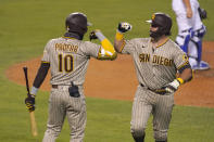 San Diego Padres' Austin Hedges, right, is congratulated by Jurickson Profar after hitting a solo home run during the fifth inning of a baseball game against the Los Angeles Dodgers Monday, Aug. 10, 2020, in Los Angeles. (AP Photo/Mark J. Terrill)