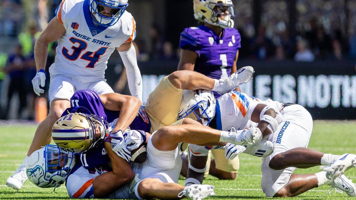 Boise State cornerback Kaonohi Kaniho and safety Seyi Oladipo bring down Washington wide receiver Jalen McMillan after a long gain earlier this season at Husky Stadium in Seattle. The Huskies’ high-powered passing game was too much for the Broncos.