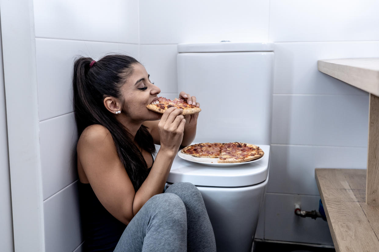 Woman eating in the toilet. (Getty Images)