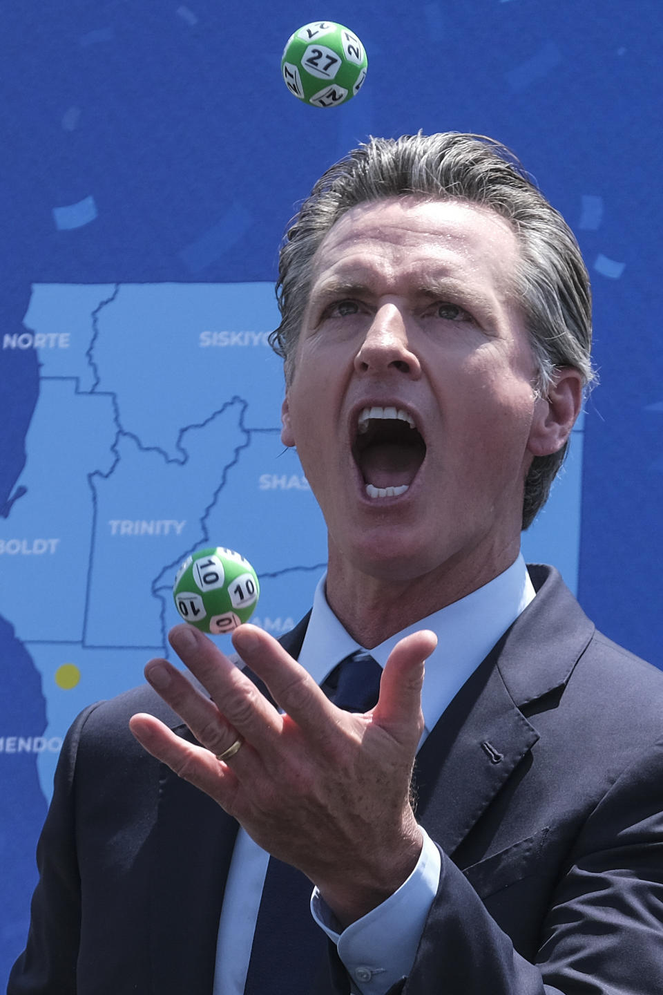 California Gov. Gavin Newsom juggles balls with winning numbers after the Vax for the Win lottery contest during a news conference at Universal Studios in Universal City, Calif., Tuesday, June 15, 2021. On Tuesday, California lifted most of its COVID-19 restrictions and ushered in what has been billed as the state’s “Grand Reopening.” (AP Photo/Ringo H.W. Chiu)