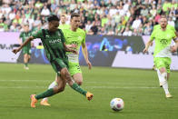 Mönchengladbach's Nathan Ngoumou Minpole, left, scores their side's second goal of the game during the German Bundesliga soccer match between Borussia Monchengladbach and Wolfsburg at the Volkswagen Arena in Wolfsburg, Germany, Sunday April 7, 2024. (Swen Pförtner/dpa via AP)