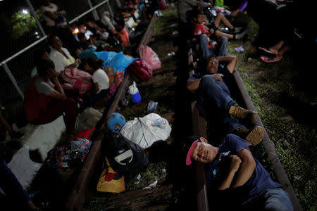 Honduran migrants, part of a caravan trying to reach the U.S., rest on the bridge that connects Mexico and Guatemala in Ciudad Hidalgo, Mexico, October 19, 2018. REUTERS/Ueslei Marcelino