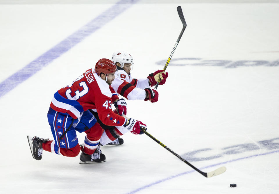 Washington Capitals right wing Tom Wilson (43) reaches for the puck past New Jersey Devils left wing Taylor Hall (9) during the second period of an NHL hockey game Friday, Nov. 30, 2018, in Washington. (AP Photo/Al Drago)