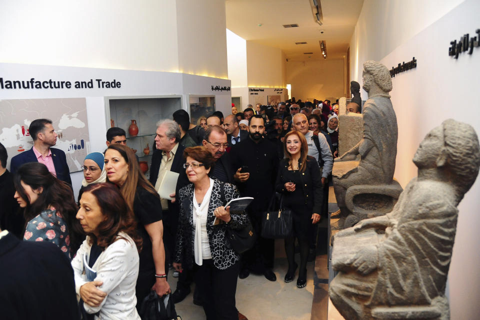 In this photo released by the Syrian official news agency, SANA, people attend the reopening ceremony for Syria's National Museum, in Damascus, Syria, Sunday, Oct. 28, 2018. Syrian officials, foreign archeologists and restoration specialists attended the Sunday reopening ceremony in the heart of Damascus more than six years after the prominent institution was shut down and emptied as the country's civil war encroached on the capital. (SANA via AP)