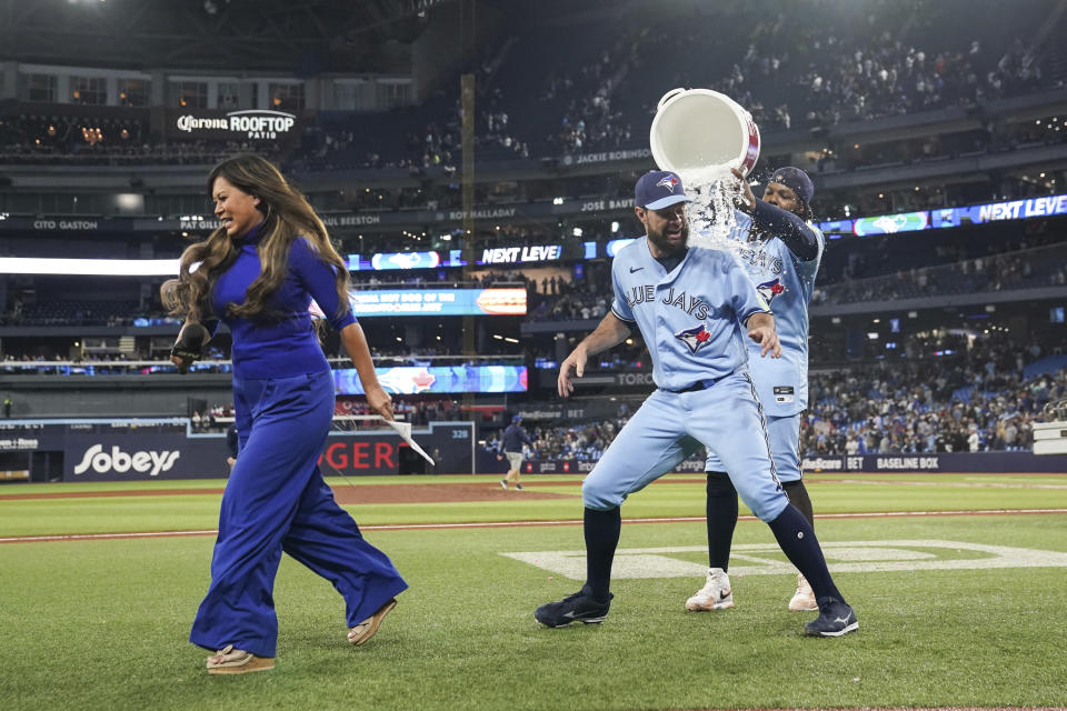 Toronto Blue Jays' Brandon Belt gets doused by Vladimir Guerrero Jr. during an interview following the team's win over the New York Yankees in a baseball game Thursday, Sept. 28, 2023, in Toronto. (Chris Young/The Canadian Press via AP)