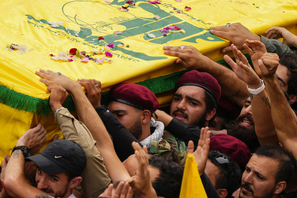 Hezbollah fighters shout slogans as carry the coffin of their comrade, Mohammed Ali Assaf, who was killed by an Israeli strike in Syria Friday morning, during his funeral procession in the southern Beirut suburb of Dahiyeh, Lebanon, Saturday, Nov. 11, 2023. Lebanon's militant Hezbollah group has announced the death of seven of its fighters without giving details on where they were killed. A Hezbollah official and a Lebanese security official said the seven fighters were killed in neighboring Syria Friday morning. (AP Photo/Hassan Ammar)