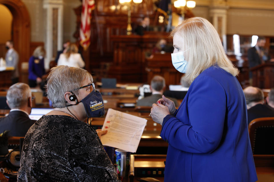 Kansas state Reps. Brenda Landwehr, left, R-Wichita, and Susan Concannon, R-Beloit, confer during a House debate on a proposed anti-abortion amendment to the Kansas Constitution, Friday, Jan. 22, 2021, at the Statehouse in Topeka, Kan. Both supported the measure, which would overturn a Kansas Supreme Court decision in 2019 that declared access to abortion a "fundamental" right under the state constitution. (AP Photo/John Hanna, Pool)