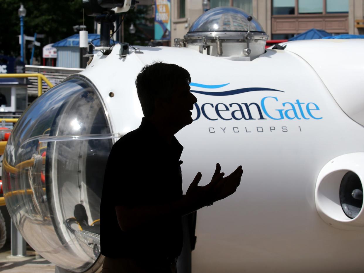 A silhouette of Stockton Rush gesturing in front of white submersible with words OceanGate on the side