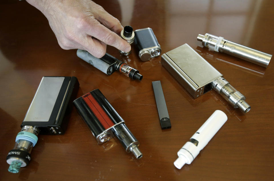 FILE - In this April 10, 2018, file photo, a high school principal displays vaping devices that were confiscated from students in such places as restrooms or hallways at the school in Massachusetts. U.S. health officials are scrambling to keep e-cigarettes away from teenagers amid an epidemic of underage use. But doctors face a new dilemma: there are few effective options for weening young people off nicotine vaping devices like Juul. (AP Photo/Steven Senne, File)