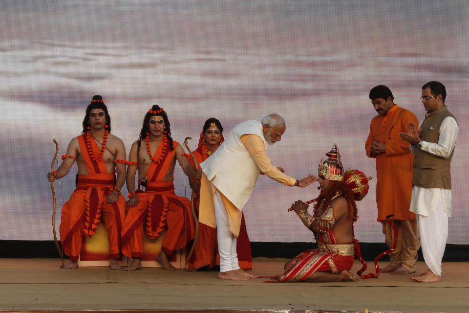 FILE - In this Oct. 8, 2019, file photo, Indian Prime Minister Narendra Modi applies vermilion on the forehead of an artist dressed as Hindu monkey god Hanuman, watched by artists dressed as Rama, his brother Lakshman and wife Sita, at an event marking the end of Dussehra festival in New Delhi, India. Seeking comfort in the certainty of the past, Indians are devouring reruns of popular Hindu religious dramas as the country’s public broadcaster has revived epic television shows like “Ramayan,” the story of Lord Ram who was sent into exile for 14 years and rescued his kidnapped wife Sita from the demon Ravan, and “Shri Krishna," both highly revered mythological tales. On April 16, 2020, the show had a record 77 million viewers, India’s public broadcaster Prasar Bharati tweeted. Prime Minister Narendra Modi has often invoked Hindu scriptures in his speeches during the lockdown, asking people to do their duty and follow social distancing rules to win the battle against COVID-19. (AP Photo/Manish Swarup, File)