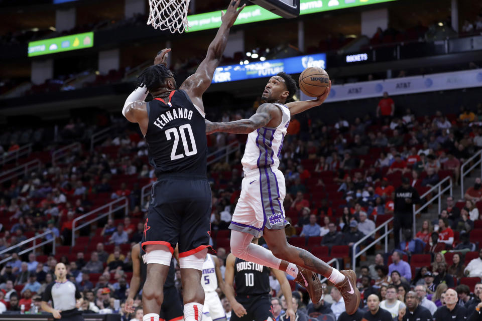 Sacramento Kings guard Malik Monk, right, goes up for a dunk as Houston Rockets forward Bruno Fernando (20) defends during the first half of an NBA basketball game Monday, Feb. 6, 2023, in Houston. (AP Photo/Michael Wyke)