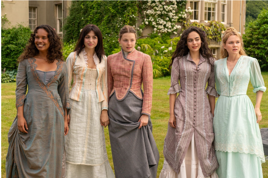 Five women in pastel dresses.