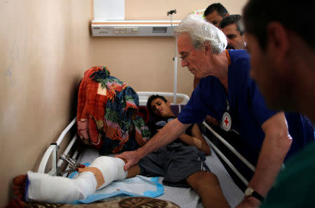 British vascular surgeon John Wolfe, who was invited to Gaza by the International Committee of the Red Cross (ICRC), checks a wounded Palestinian in a hospital in Gaza City April 24, 2018. REUTERS/Suhaib Salem