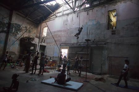 A child climbs a rope during a training session at a circus school in Havana, October 6, 2014. REUTERS/Alexandre Meneghini