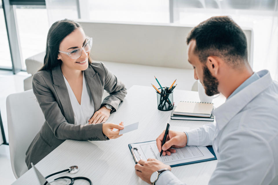 Man signing up for healh insurance with female insurance agent