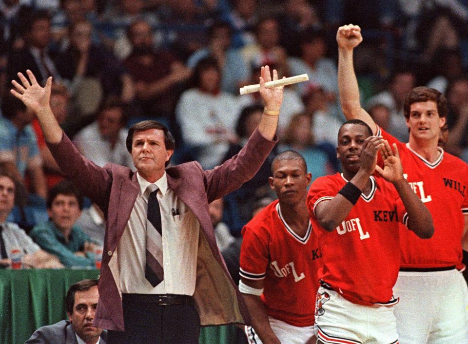 Louisville coach Denny Crum gestured towards his team as players from the bench began to celebrate during the closing moments of their 88-77 victory over LSU in the NCAA semifinals on March 29, 1986 in Dallas. Louisville went on to win the championship over Duke, 72-69.FILE--Louisville coach Denny Crum gestures towards his team as players from the bench begin to celebrate during the closing moments of their 88-77 victory over LSU in the NCAA semi-finals in this March 29, 1986 photo in Dallas. Louisville went on to win the championship over Duke. Crum will retire after the season, ending a 30-year career at Louisville in which he coached the Cardinals to six Final Fours and two national championships.  