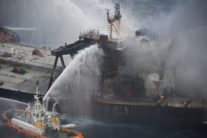 A Sri Lankan Navy boat sprays water on the New Diamond, a very large crude carrier (VLCC) chartered by Indian Oil Corp (IOC), that was carrying the equivalent of about 2 million barrels of oil, after a fire broke out off east coast of Sri Lanka