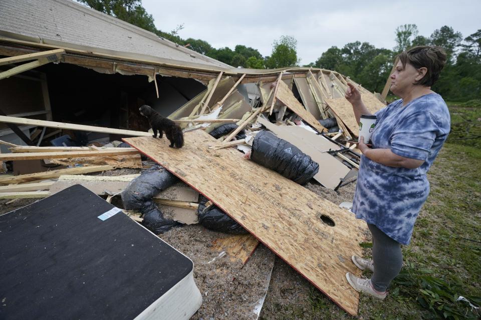 Vickie Savell looks at the remains of her new mobile home early Monday, May 3, 2021, in Yazoo County, Miss. Multiple tornadoes were reported across Mississippi on Sunday, causing some damage but no immediate word of injuries. (AP Photo/Rogelio V. Solis)