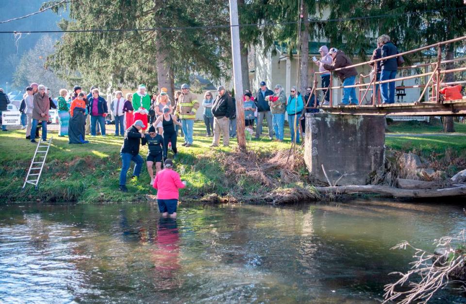 “Super plungers,” who went underwater three times, wade into Penns Creek on Saturday with cheers from the crowd during the YMCA of Centre County Polar Bear Plunge.