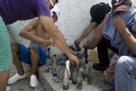 Opositores preparan bombas molotov durante un enfrentamiento con la policía en la protesta contra el gobierno de Nicolás Maduro, en Valencia Venezuela, el miércoles 26 de febrero de 2014. Las protestas iniciaron con estudiantes en distintas ciudades, quienes están molestos por el crimen, los problemas económicos y la mano dura con la que la policía les ha respondido. (AP Photo/Rodrigo Abd)