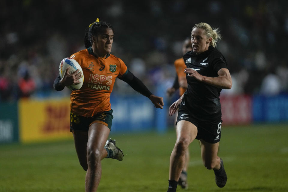 Australia's Sariah Paki, left, is chased by New Zealand's Kelly Brazier during the final match in the Hong Kong Sevens rugby tournament in Hong Kong, Sunday, April 2, 2023. (AP Photo/Louise Delmotte)