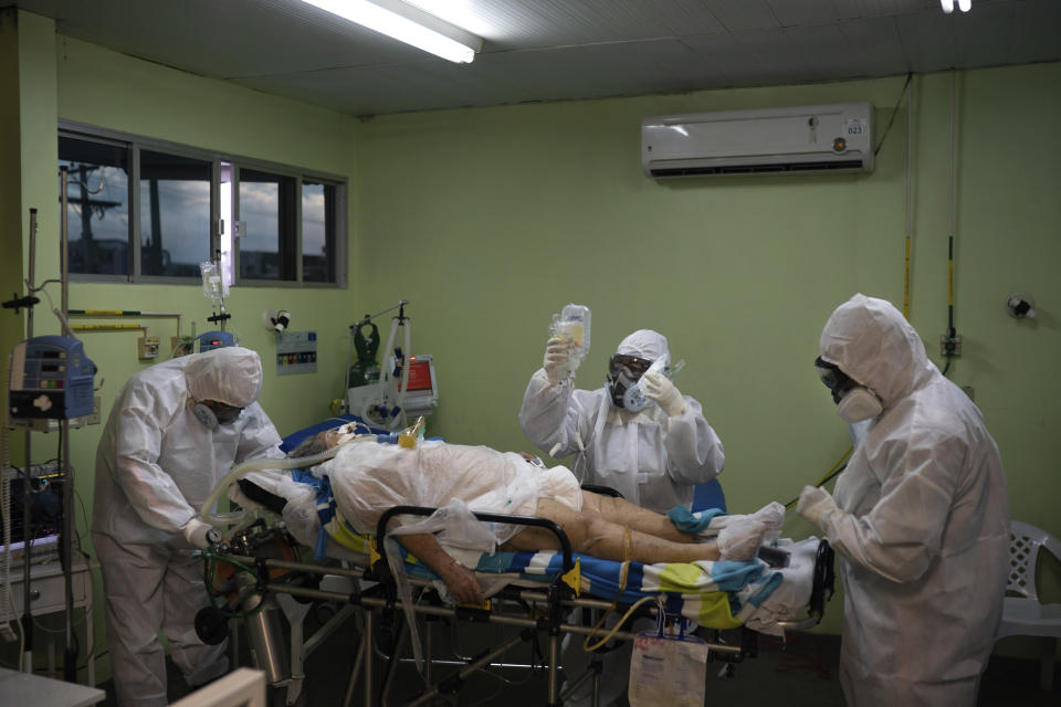 Emergency workers transfer a COVID-19 patient to a hospital in Manaus, Brazil, Friday, May 15, 2020. Per capita, Manaus is Brazil's major city hardest hit by COVID-19. (AP Photo/Felipe Dana)