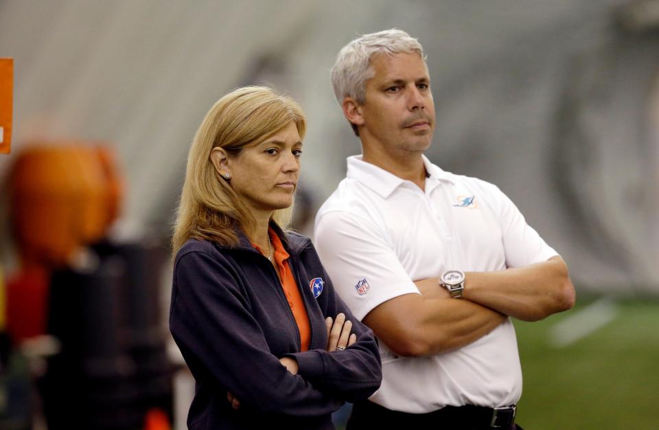 FILE - Dawn Aponte, executive vice-president of football administration for the Miami Dolphins, left, stands with general manager Dennis Hickey, right, during an NFL training camp practice, Sunday, Aug. 16, 2015, in Davie, Fla. Now the NFL's chief football administrative officer, Aponte began in the NFL in the early 1990s, when women barely felt welcomed and were often ignored or overlooked. (AP Photo/Lynne Sladky, File)