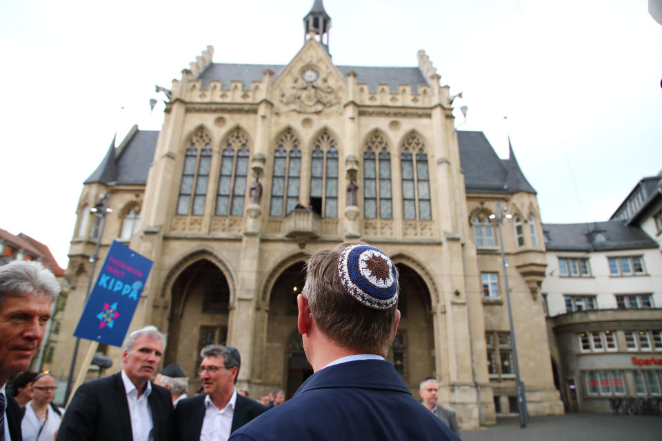 Thuringia's State Premier Bodo Ramelow (C) wears a kippa during the rally.