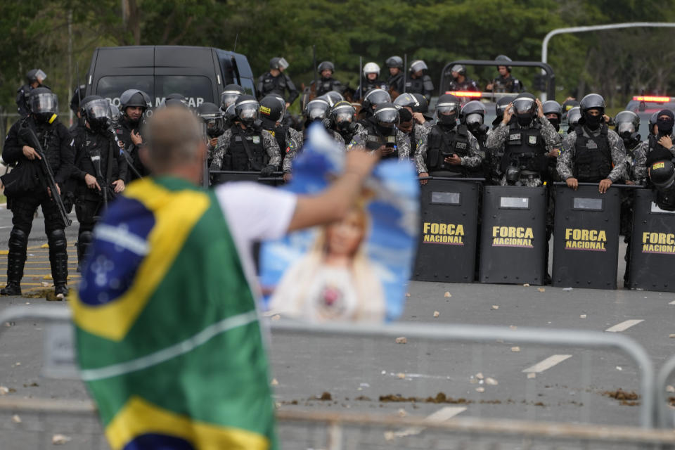 A protesters, supporter of Brazil's former President Jair Bolsonaro, in confronted by a police phalanx after the demonstrators stormed the Planalto Palace in Brasilia, Brazil, Sunday, Jan. 8, 2023. Planalto is the official workplace of the president of Brazil. (AP Photo/Eraldo Peres)