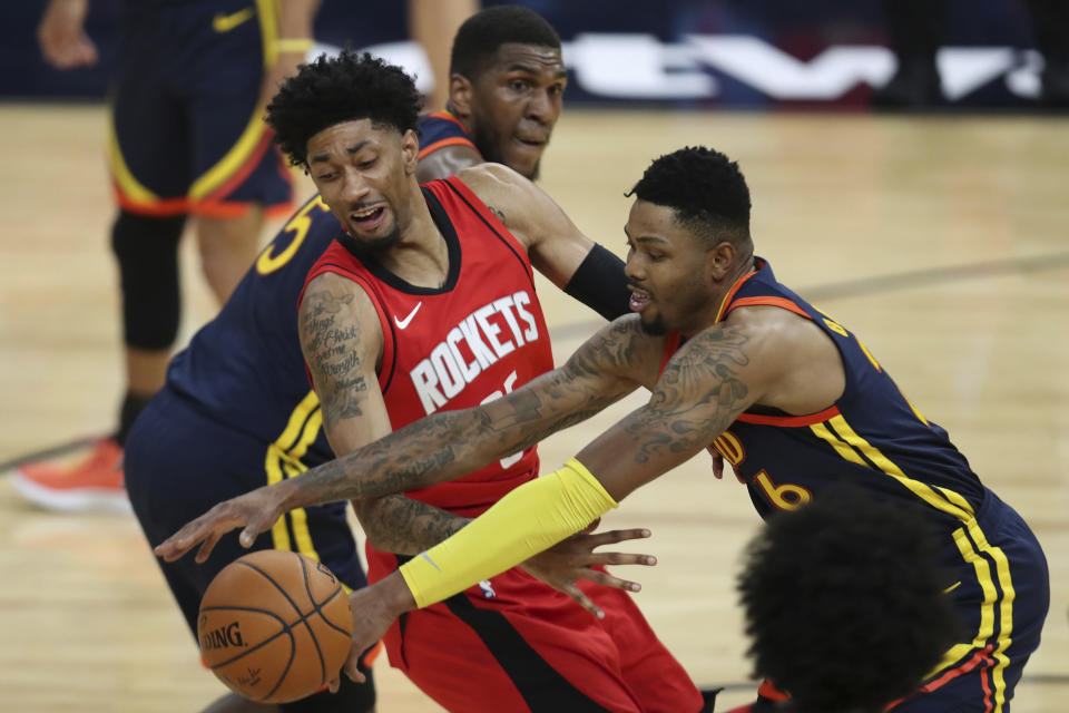 Golden State Warriors guard Kent Bazemore, right, reaches for the ball next to Houston Rockets forward Christian Wood during the first half of an NBA basketball game in San Francisco, Saturday, April 10, 2021. (AP Photo/Jed Jacobsohn)