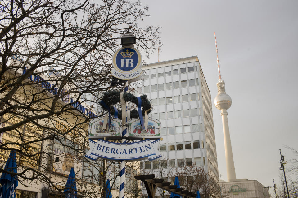 The entrance sign of Hofbraeu Berlin is seen in front of Berlin's biggest restaurant, with the television tower in the background in Berlin, Germany, Thursday, Dec. 17, 2020. The restaurant which had to closed due to the corona pandemic has opened its doors for homeless people. Starting this week the Hofbraeu Berlin offers free meals, a place to warm up and counseling for up to 150 homeless people per day. (AP Photo/Markus Schreiber)