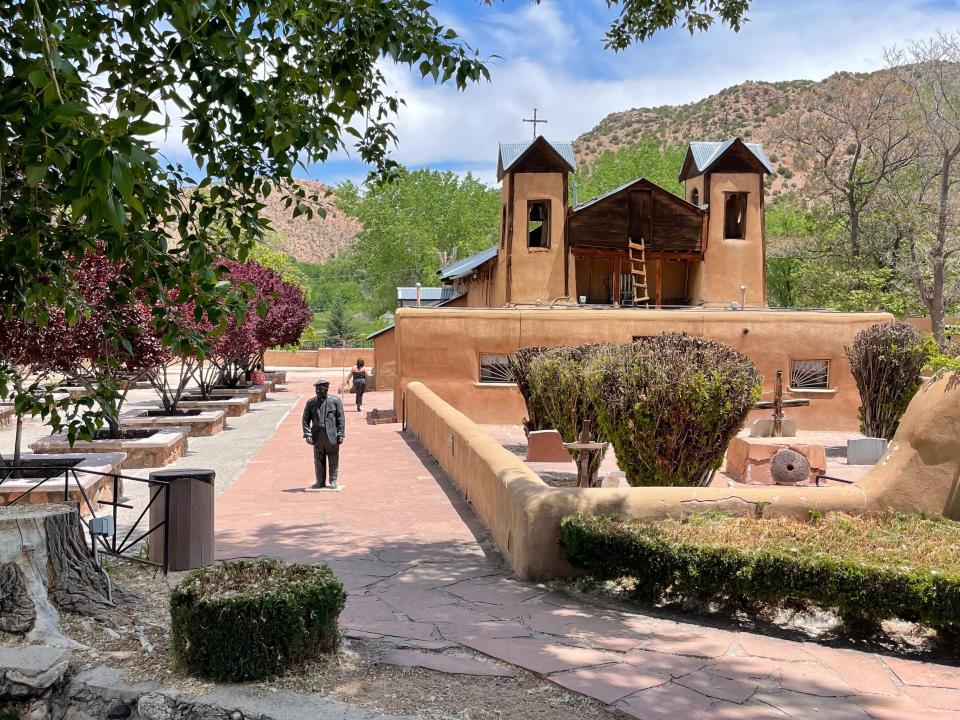 El Santuario de Chimayo, a Catholic Church surrounded by trees and beautiful landscapes.