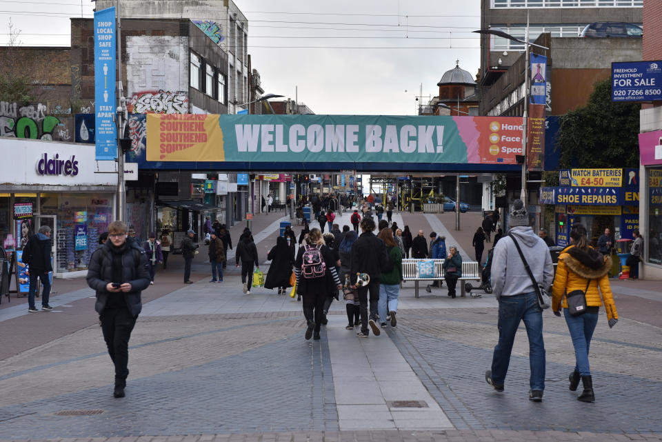 SOUTHEND, ENGLAND - APRIL 12: People walk on the high street under a bridge with a banner saying 