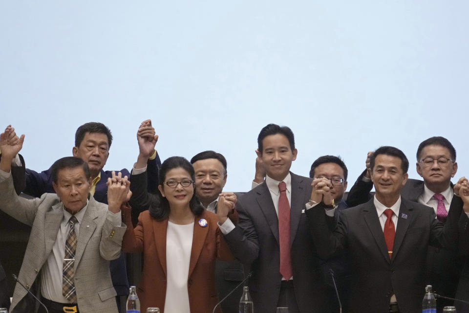 Leader of Move Forward Party Pita Limjaroenrat, third from left in front row, raises his hand with other party leaders during press conference in Bangkok, Thailand, Thursday, May 18, 2023. Thailand's election winner Move Forward Party on Thursday announced an 8-party coalition that its leader declared will become a "democratic government of the people. (AP Photo/Sakchai Lalit)